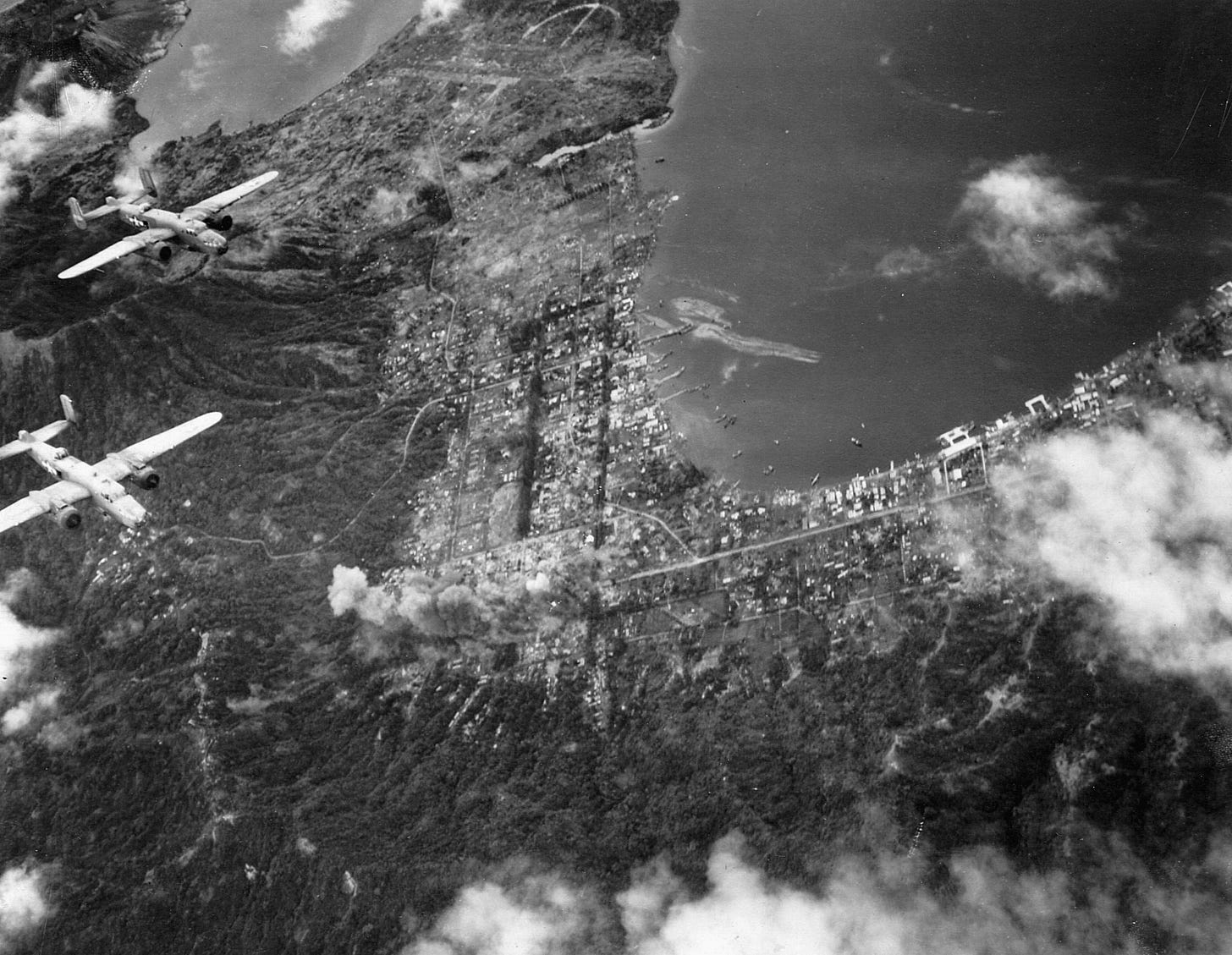 U.S. B-25 Mitchell bombers of the 13th Air Force wing their way above the Japanese bastion at Rabaul in March 1944. The major Japanese supply base and staging area was repeatedly bombed during the American offensive in the South Pacific. U.S. B-25 Mitchell bombers of the 13th Air Force wing their way above the Japanese bastion at Rabaul in March 1944. The major Japanese supply base and staging area was repeatedly bombed during the American offensive in the South Pacific.